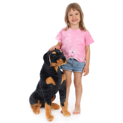 Rottweiler plüss kutya ül egy kislány mellett